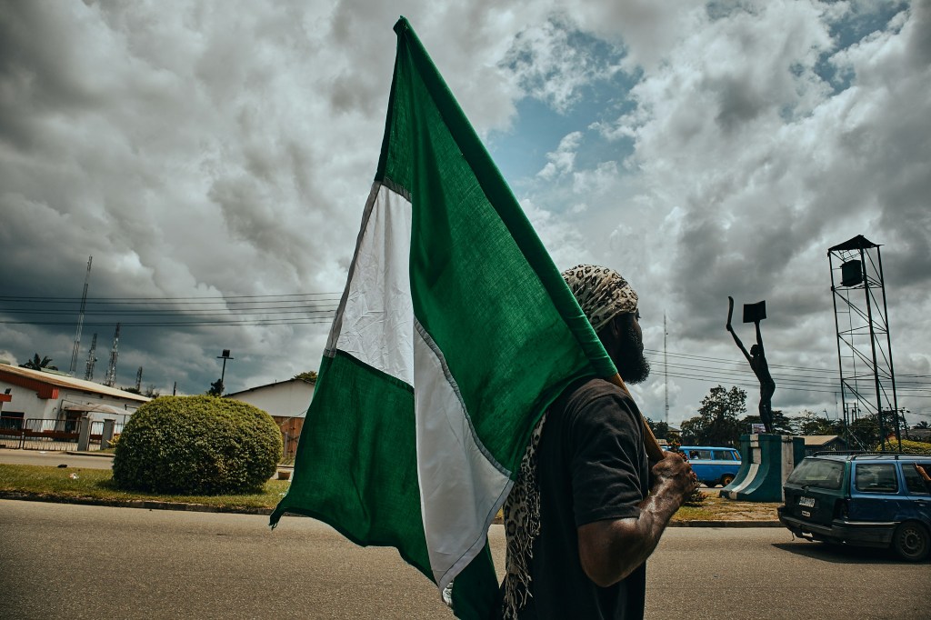 Image of Nigerian man holding national flag